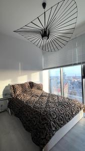 a bedroom with a bed and a large chandelier at Hanza Tower Level XV Signature in Szczecin