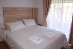 a bedroom with a white bed with two towels on it at Hotel Campestre Kambra in Garagoa +2 photos