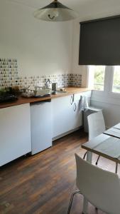 a kitchen with white cabinets and a table with chairs at Résidence Castors Colombes in Colombes