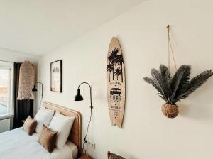 a bedroom with a bed and a surfboard on the wall at Multi-bedroom stay 9 Rooms near Beach in Zoutelande