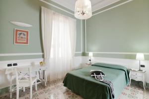 a bedroom with a green bed and a table and chair at Palazzo Lombardo in Florence