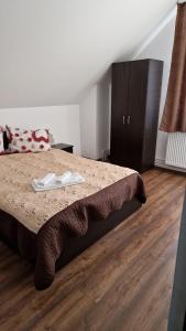a bedroom with a bed and a wooden floor at Cabana Angela in Râșca