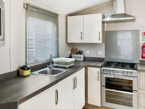 a kitchen with a sink and a stove top oven at 54 Beach Retreat in Burnham on Sea