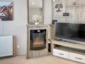 a living room with a fireplace and a television at 54 Beach Retreat in Burnham on Sea