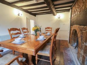a dining room with a wooden table and chairs at Manor Cottage in Ilminster