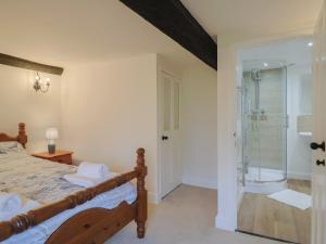 a bedroom with a bed and a walk in shower at Manor Cottage in Ilminster +32 photos
