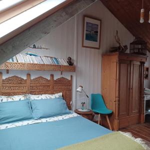a bedroom with a blue bed and a blue chair at Rue des dolmens in Saint-Quay-Portrieux