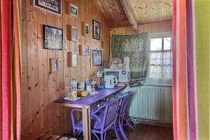 a kitchen with a table with purple chairs and a microwave at Rue des dolmens in Saint-Quay-Portrieux +27 photos
