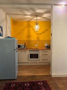 a kitchen with a white refrigerator and a yellow wall at Vorderer Westen Kassel in Kassel