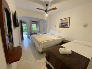 a hotel room with two beds and a couch at Velejador Hotel, a 5 minutos do Centro Histórico, com estacionamento! in Paraty +25 photos