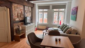 a living room with a couch and a table at Momento Heidkrug in Lüneburg
