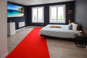 a bedroom with a bed and a red rug at Suite Cinéma #7#- Jacuzzi in Roubaix
