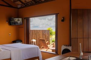 a bedroom with a bed and a view of a patio at Santo Cipó - Cabanas Românticas pertinho de BH - Privacidade total e vista deslumbrante in Jaboticatubas