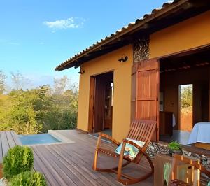 a deck with a table and chairs on a house at Santo Cipó - Cabanas Românticas pertinho de BH - Privacidade total e vista deslumbrante in Jaboticatubas