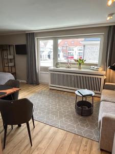 a living room with a couch and a window at Mittendrin 102 in Sylt