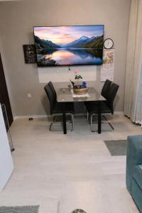 a dining room with a table and a tv on the wall at Apartma Xanadu in Slovenske Konjice +23 photos