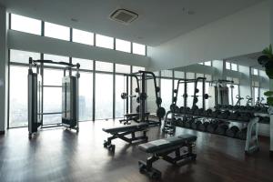a gym with several tread machines in a room with windows at The Snowbell Hotel & Spa at The Bridge in Phnom Penh