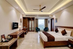 a hotel room with a bed and a desk at Hotel Peridot with Free Airport Pickup in New Delhi