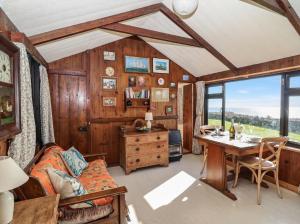 a living room with a table and a couch and a desk at The Cabin in Cawsand +10 photos