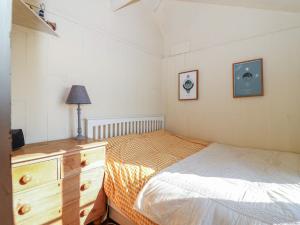 a bedroom with a twin bed and a dresser and a dresser at The Cabin in Cawsand