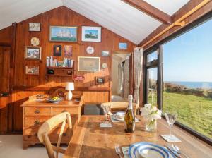 a dining room with a table and a view of the ocean at The Cabin in Cawsand