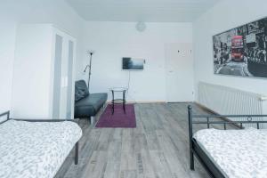a room with two beds and a couch and a tv at FREYZEIT Apartment "Gässel" in der Altstadt von Speyer für bis zu 6 Personen in Speyer