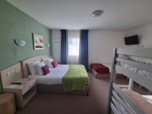a hotel room with a bed and bunk beds at Hôtel Le Kolibri in Tournus +53 photos