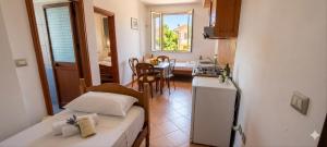 a small room with a bed and a kitchen with a table at Marconi Apartments in Durrës