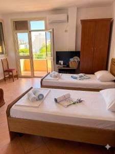 a hotel room with two beds with towels on them at Marconi Apartments in Durrës