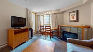 a living room with a tv and a fireplace at Whistler Peak Lodge in Whistler