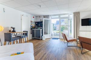 a room with a bed and a table and chairs at Hotel Kijkduin in Domburg