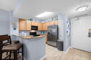 a kitchen with a counter and a refrigerator at 5 Star Resort 2BR 2 BATH King Suite Shuttle Pools Across from Beach 2208 in Destin
