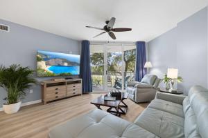 a living room with a couch and a ceiling fan at 5 Star Resort 2BR 2 BATH King Suite Shuttle Pools Across from Beach 2208 in Destin +35 photos
