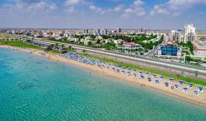an aerial view of a beach with umbrellas and people at MyGuest Cornelius 70 , 1-Bedroom Luxury Apartment in Iskele