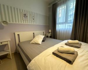 a bedroom with a bed with towels on it at MyGuest Cornelius 70 , 1-Bedroom Luxury Apartment in Iskele +10 photos