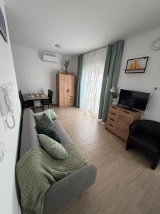 a living room with a couch and a television at Sunset Bay Casa in Dolac