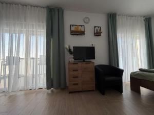 a living room with a television on a dresser with a chair at Sunset Bay Casa in Dolac