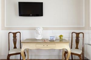 a table with two chairs and a tv on a wall at Palazzo Lombardo in Florence