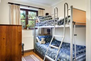 a bedroom with bunk beds with a teddy bear sitting on a bed at 4 Bed in Upton Cross oc-j34643 in Upton