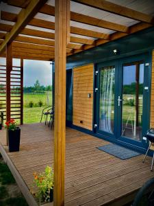 a wooden deck with a pergola at Cisy Resort-idealny dla gości ze zwięrzętami,ogrodzony teren na wyłączność,150 m od jeziora in Makosieje