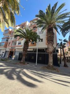 a group of palm trees in front of a building at Vivienda 01 Appartement moderne au cœur de Mohammedia , Calme et Confort in Mohammedia