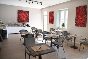 a restaurant with tables and chairs and red paintings on the walls at Hotel Bel Ami Tirana in Tirana
