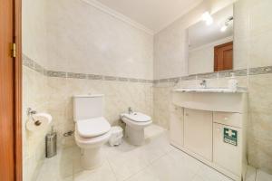 a bathroom with a toilet and a sink at Ocean Gardens Apartment by Mth in Caniço +16 photos