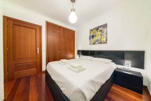 a bedroom with a large bed with white sheets at Ocean Gardens Apartment by Mth in Caniço