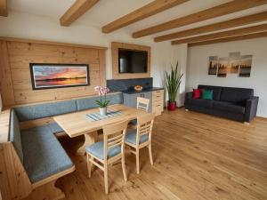 a living room with a table and a couch at Panorama Suite am Marschbachhof in Walchsee