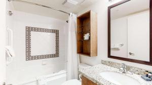 a white bathroom with a sink and a mirror at Whistler Peak Lodge in Whistler +74 photos