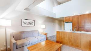 a living room with a couch and a kitchen at Whistler Peak Lodge in Whistler