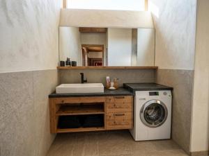 a bathroom with a washing machine and a mirror at Panorama Suite am Marschbachhof in Walchsee +7 photos