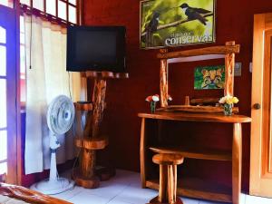 een kamer met een televisie en een tafel met een ventilator bij Hosteria Don Elias in Puyo