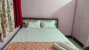 a bedroom with a bed with white sheets and pillows at Atithi homestay Solapur in Solapur +9 photos